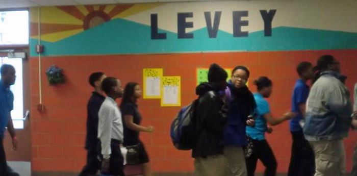Students walk past a Levey mural on their way home